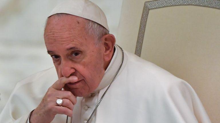 O papa Francisco está pensativo, com uma das mãos sobre a boca.