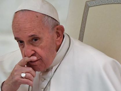 O papa Francisco está pensativo, com uma das mãos sobre a boca.