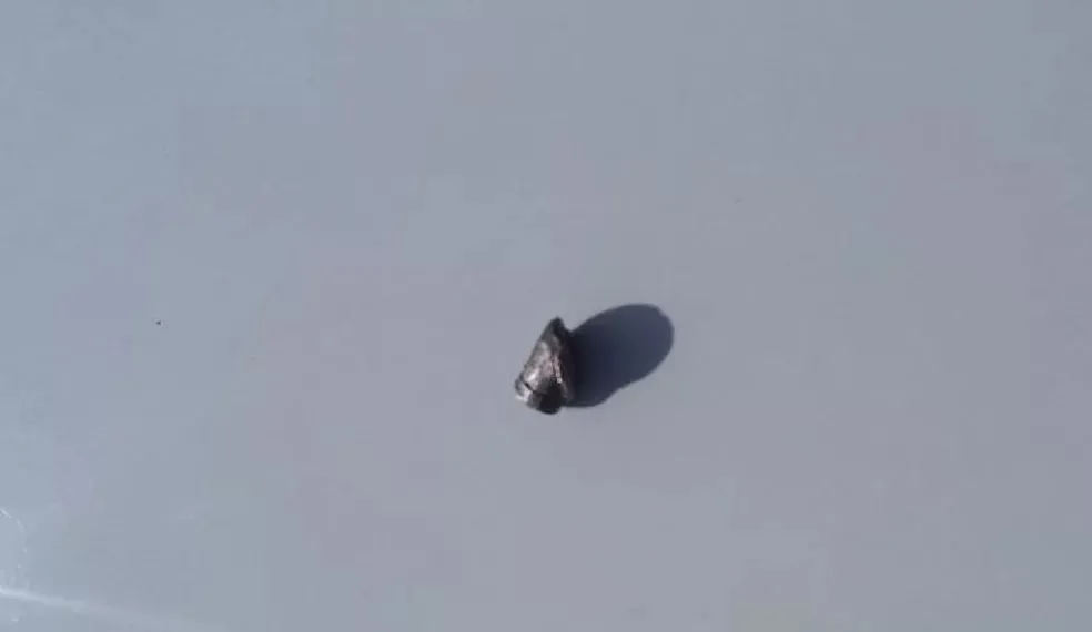 O projétil amassado foi encontrado pela polícia no local do crime.