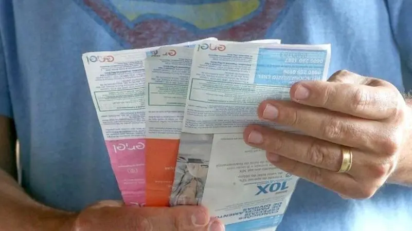 Homem segurando contas de energia