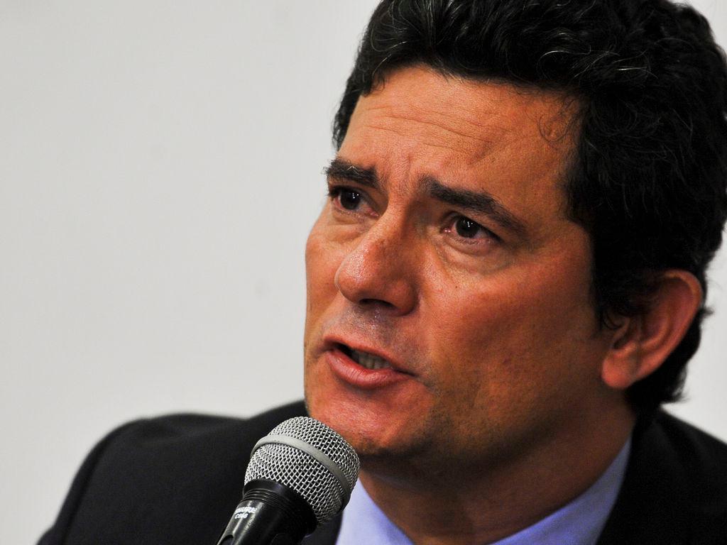 O ex-juiz e ex-ministro Sérgio Moro de perfil. Ele está falando ao microfone. Seu semblante é sério.