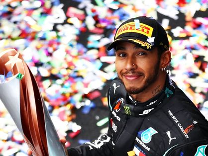 Lewis Hamilton com troféu na mão comemora conquista com a Mercedes