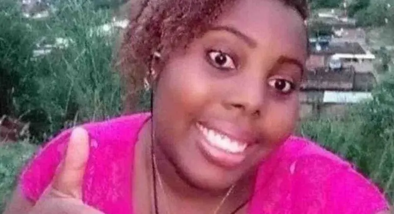 Selfie da influenciadora Aline Borel. Ela está de blusa rosa, sorrindo e fazendo um joinha com o dedo.