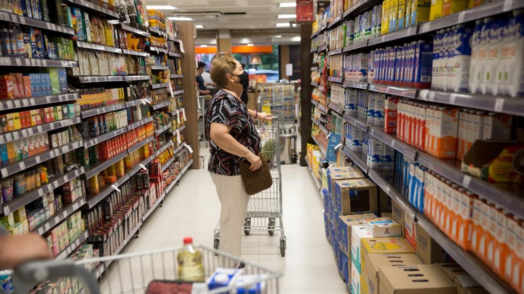 Mulher consulta preços nas prateleiras de supermercado de Fortaleza
