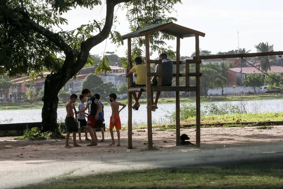 Crianças brincam em parquinho perto da lagoa da Vila União.