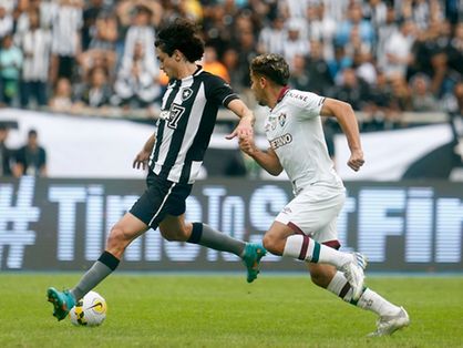 Imagem mostra dois jogadores disputando bola de futebol