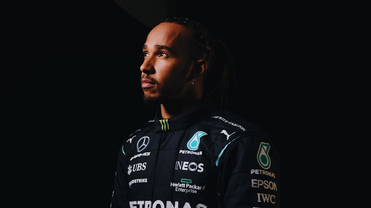 Lewis Hamilton com semblante sério em fundo preto