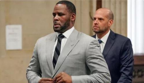 R. Kelly ajusta o terno ao entrar no tribunal.