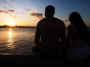 Casal vendo o pôr do sol na praia do Náutico, em Fortaleza