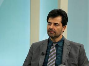 Adolfo Sachsida é ministro de Minas e Energia. Ele está de terno cinza, camisa azul petróleo e gravata listrada. A barba está por fazer.