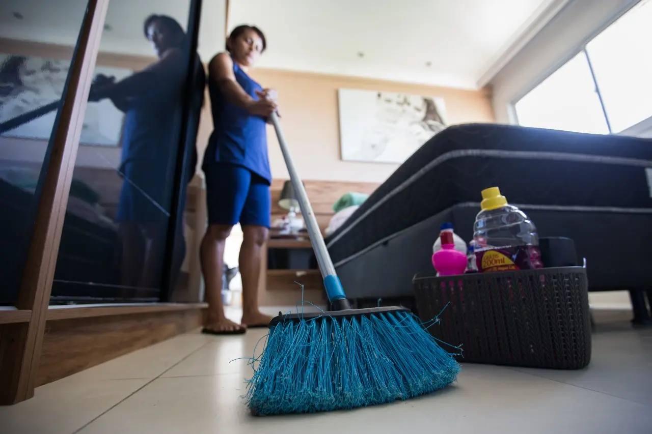 trabalhador doméstico varrendo a casa