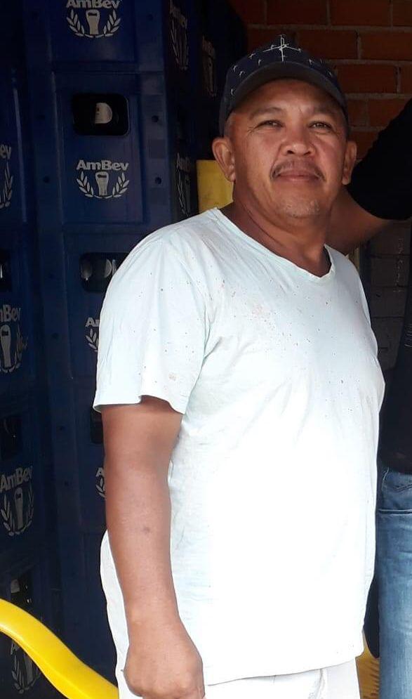 Ronaldo Pereira é um homem de meia idade. Ele está usando camisa branca e boné azul.