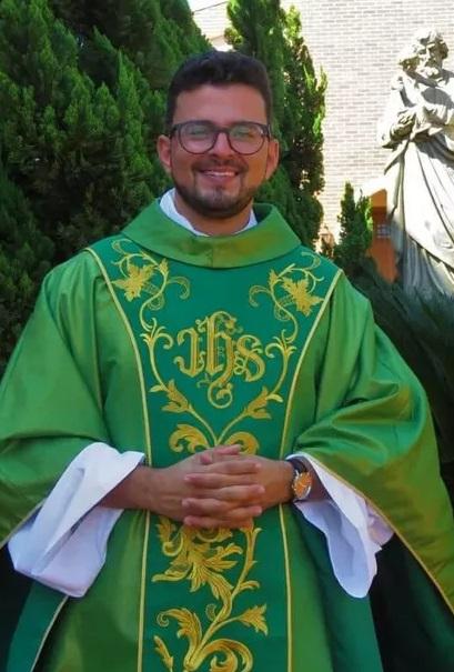 Padre Gustavo está sorrindo e com as mãos juntas.