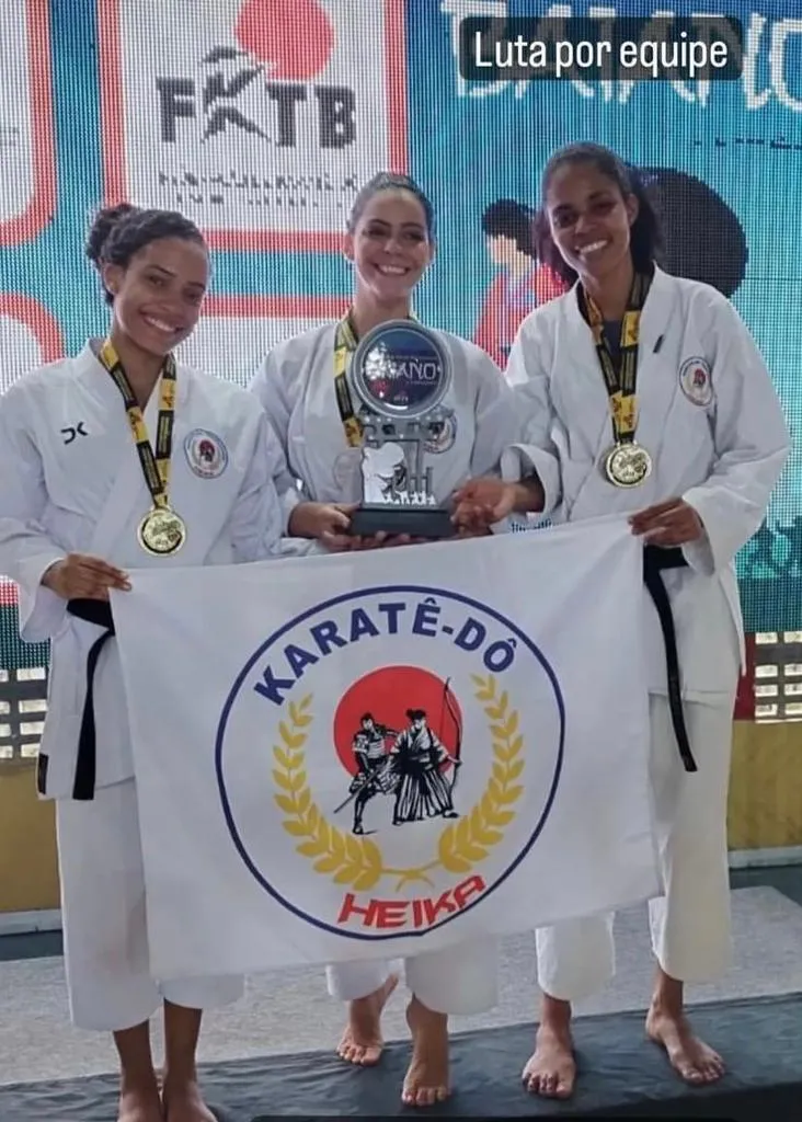 Adriele (à direita da foto) com colegas de equipe durante premiação