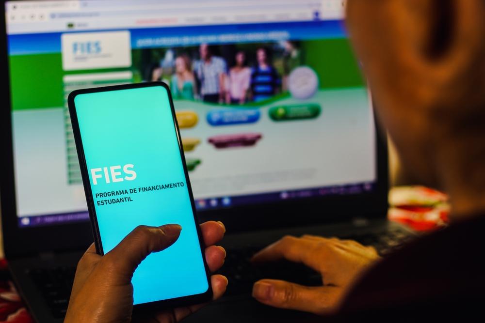 Pessoa segura telefone aberto no aplicativo do Fies.