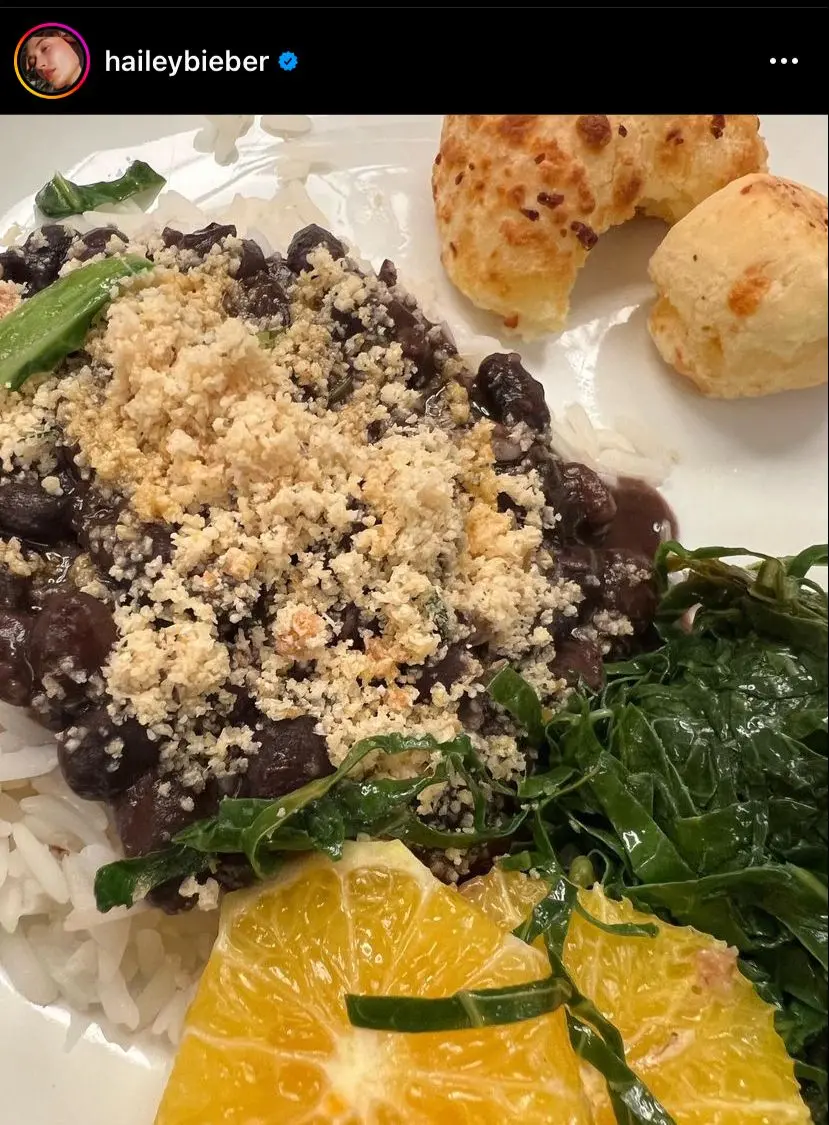 Postagem de Hailey mostra prato de feijoada com dois pães de queijo mordidos ao lado.