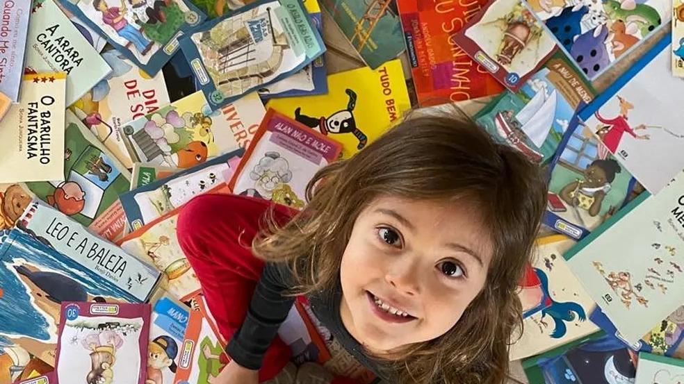 Nina com vários livros infantis