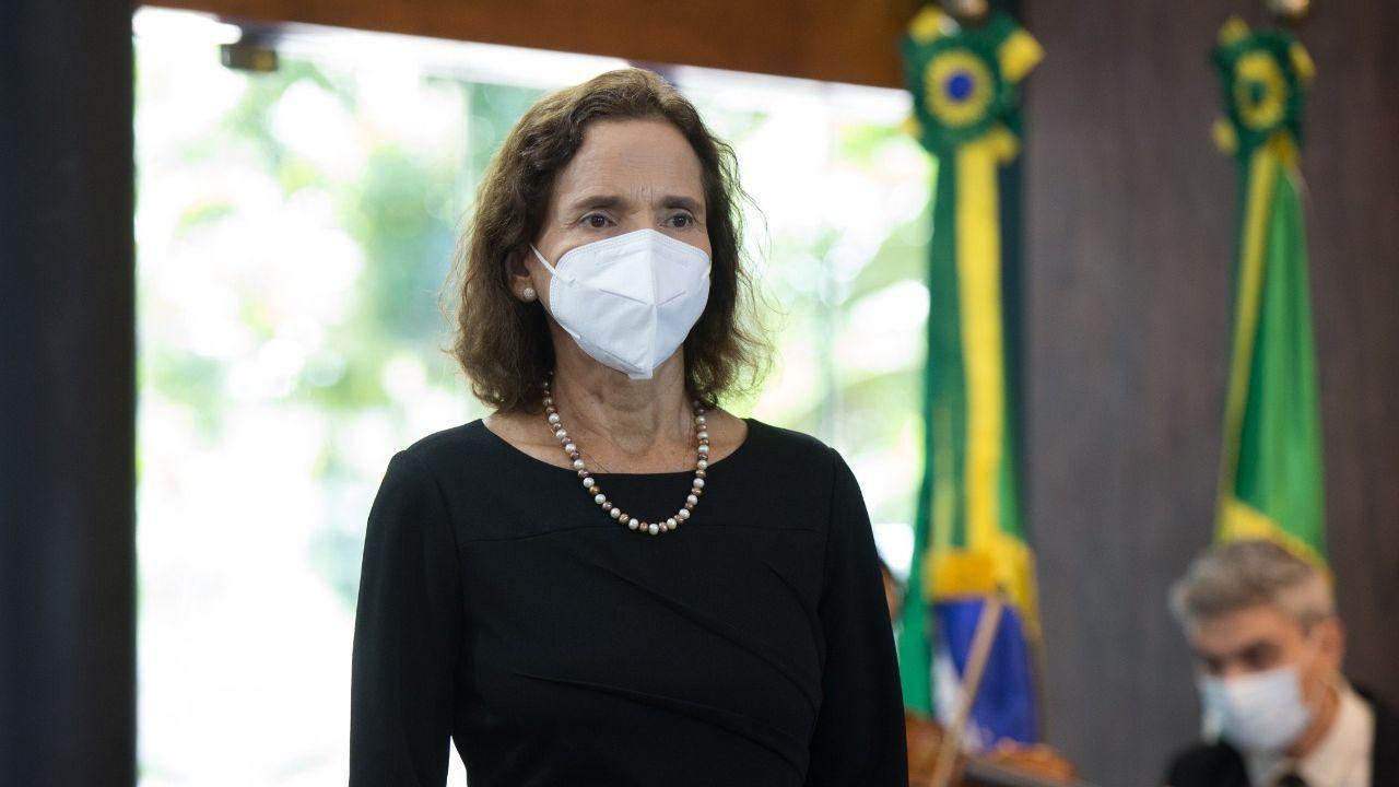 A governadora Izolda Cela está usando um vestido preto e uma máscara branca.