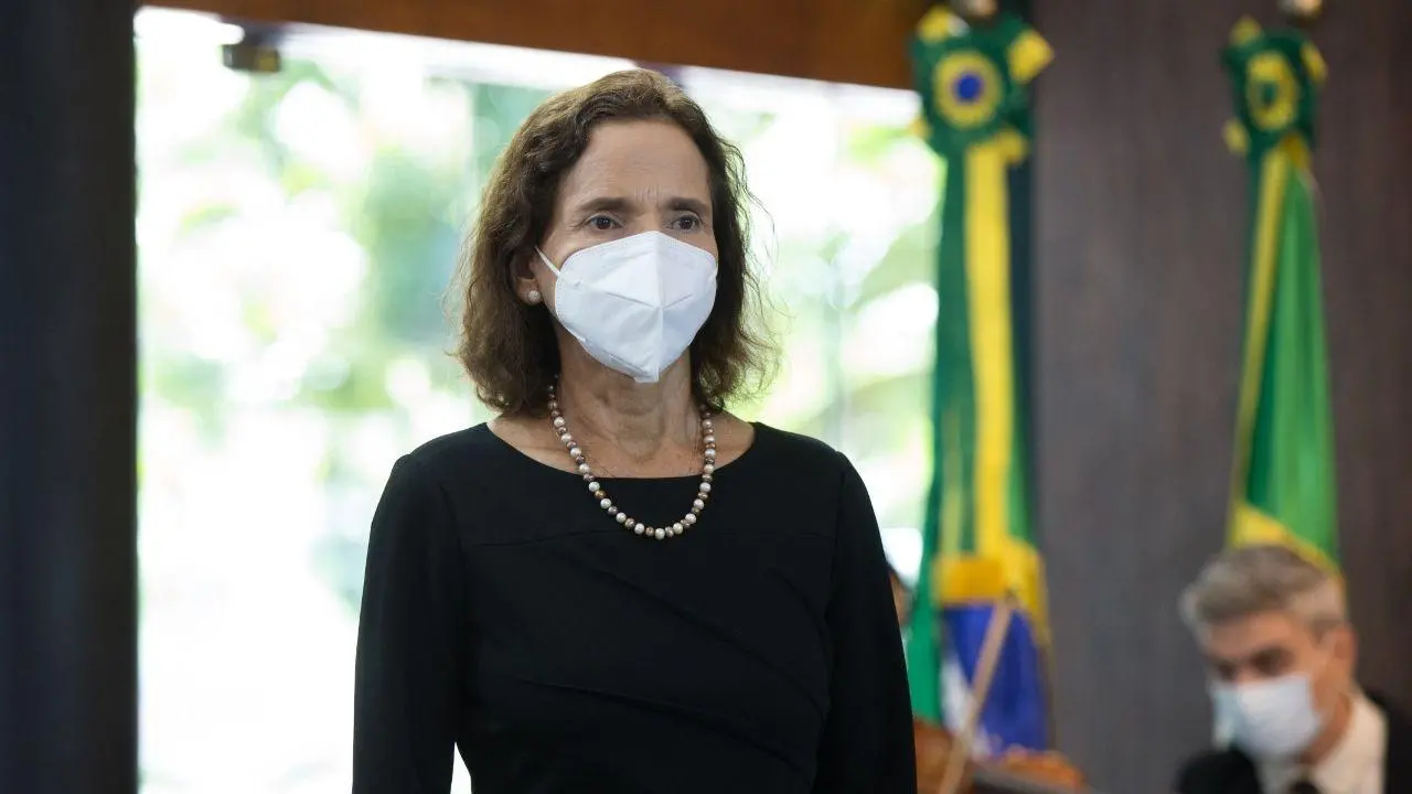 A governadora Izolda Cela está usando um vestido preto e uma máscara branca.
