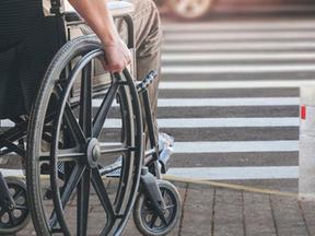 Pessoa em cadeira de rodas tenta atravessar rua sem acessibilidade