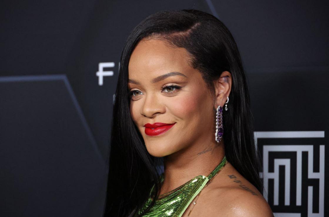 Rihanna sorrindo durante sessão de fotos em desfile da Fenty