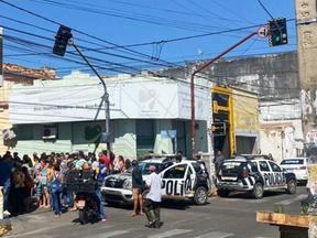 Viatura da Polícia Militar do Ceará e população aglomerada em cena de crime em Juazeiro do Norte