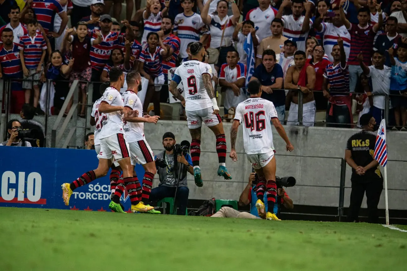 Imagem mostra jogadores de futebol comemorando gol