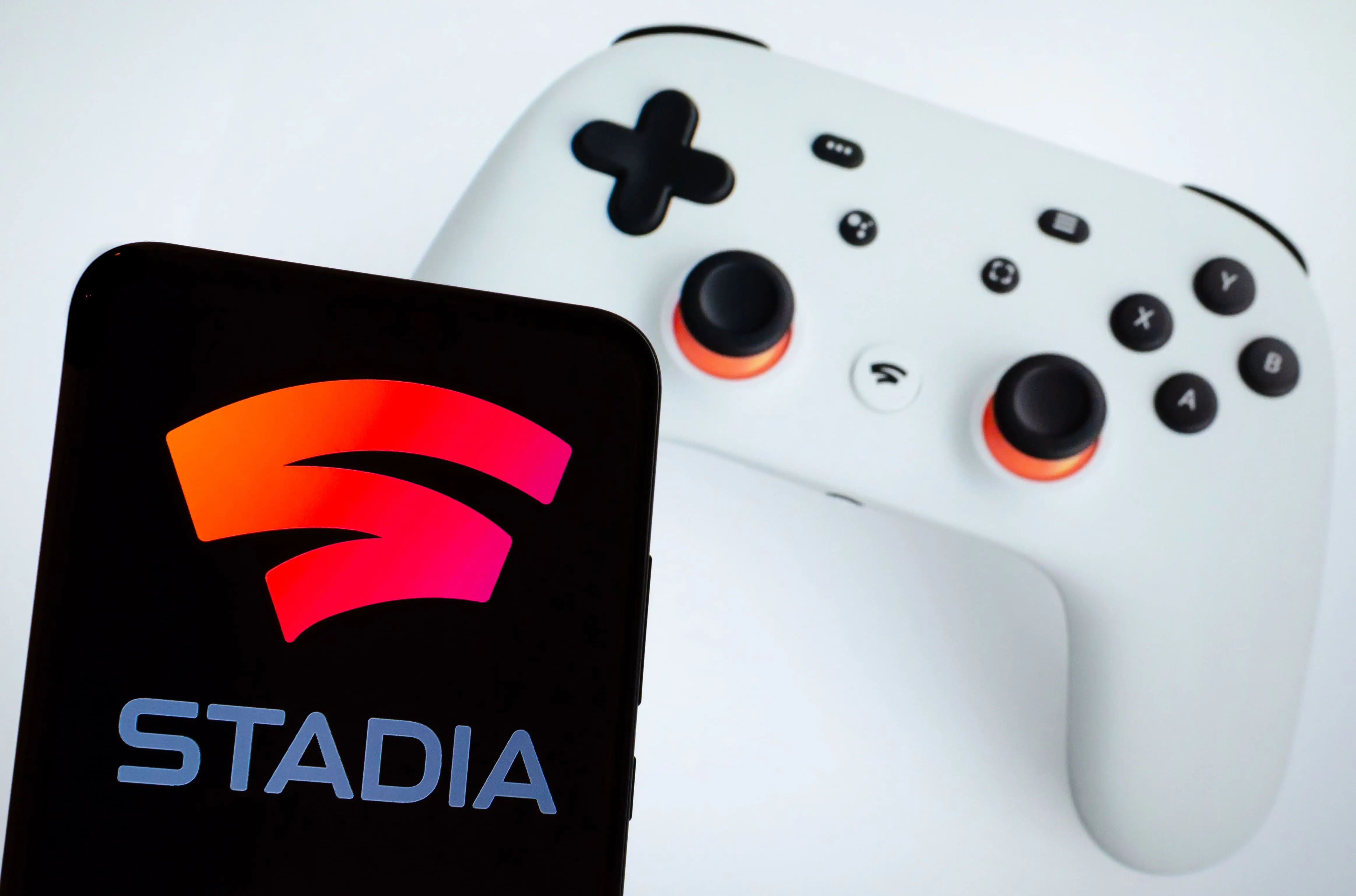 Imagem mostra console de videogame e celular ligado no Google Stadia