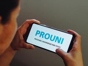 Menino segura celular aberto no app do Prouni
