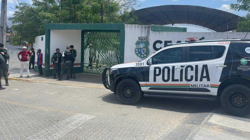 Fachada da Escola de Ensino Médio de Tempo Integral Professora Carmosina Ferreira Gomes e uma viatura da polícia
