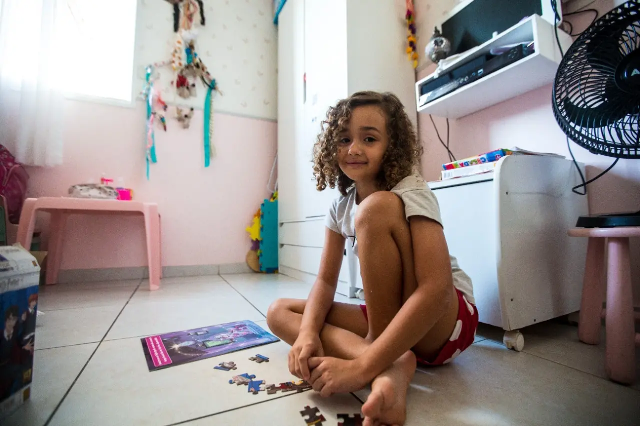 Maya sentada no quarto