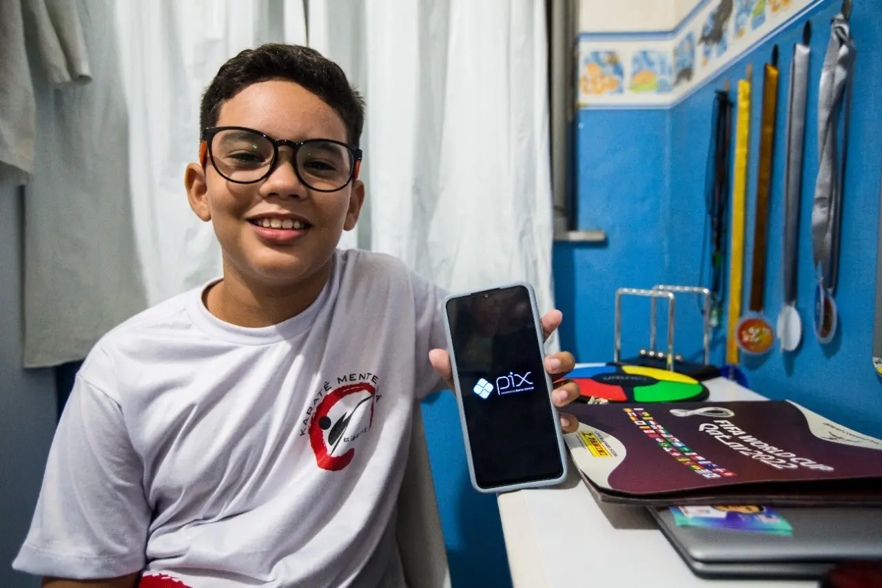 Marcus segura celular aberto com app do Pix