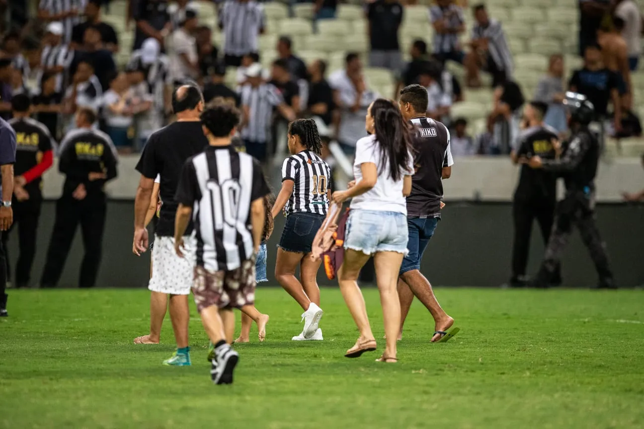Parte da torcida passou pelo gramado para fugir de confusão na arquibancada.