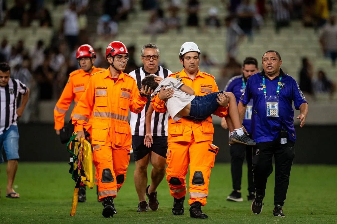 Um bombeiro carregou uma criança no colo durante a confusão na Arena Castelão