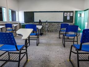 Sala de aula vazia com carteiras e quadro branco