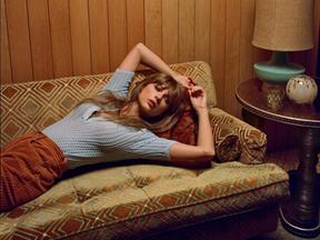 Taylor Swift deitada em foto divulgando o álbum 'Midnights'