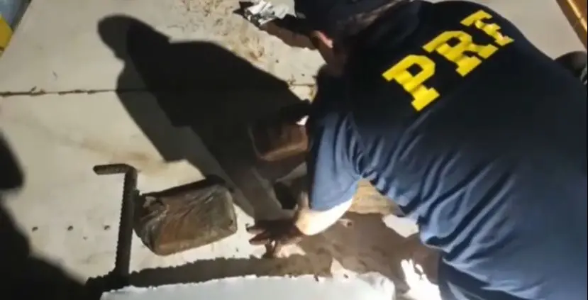 Polícia abre fundo falso de carroceria e descobre drogas escondidas.