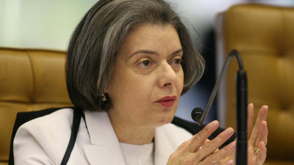 Ministra Carmén Lúcia é uma mulher idosa e branca de cabelos curtos e cinzentos. Ela está usando um terno e uma blusa branca.