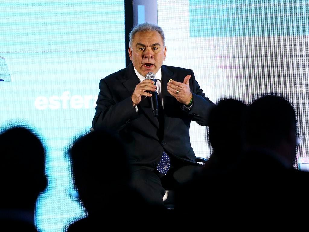 Marcelo Queiroga fala a plateia. Ele está segurando um microfone e gesticulando