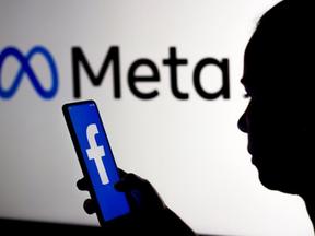 Pessoa usando o aplicativo Facebook e o logo da Meta no fundo