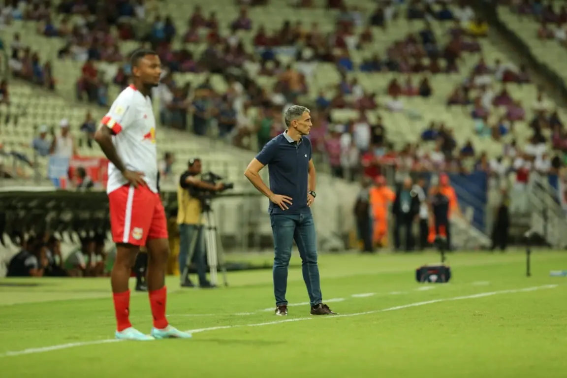 Imagem mostra duas pessoas em pé no campo