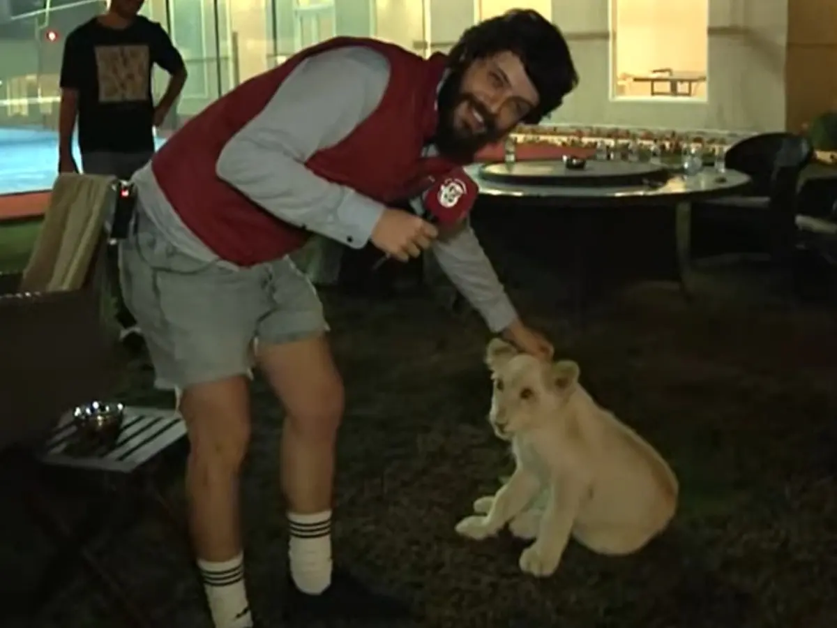 diogo defante faz carinho em um leão no catar, país sede da copa do mundo 2022
