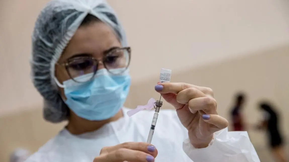 enfermeira manuseando seringa com vacina