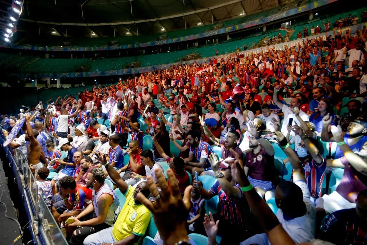 Imagem mostra torcedores com os braços levantados, durante votação
