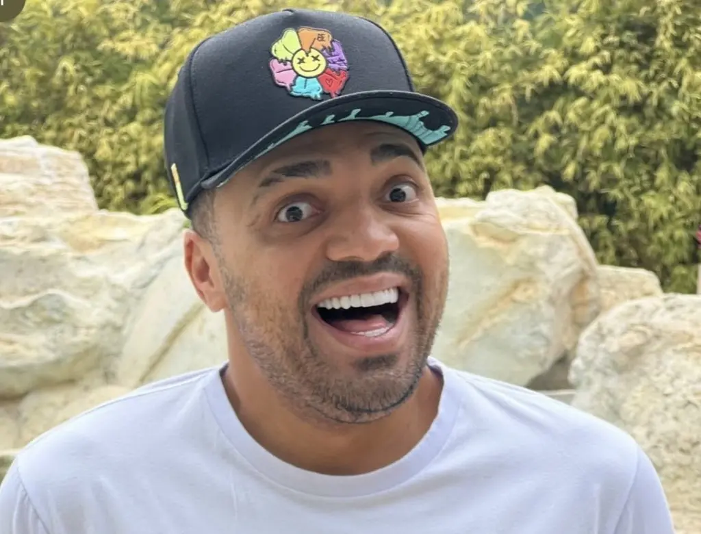 Humorista Tirullipa sorrindo e de boné