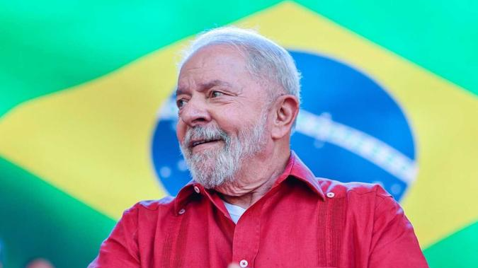 Lula com uma bandeira do Brasil atrás