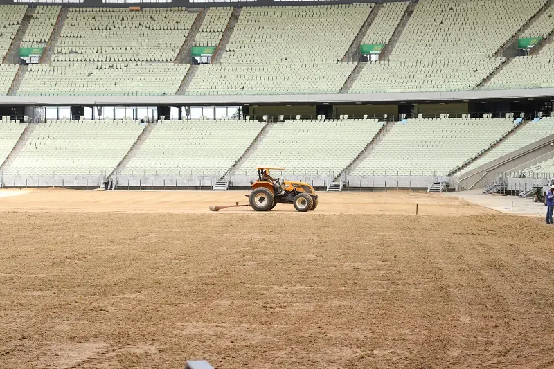 Imagem mostra campo de futebol e trator