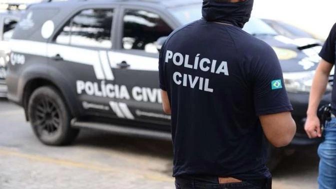 Policial civil com camisa em frente a um carro