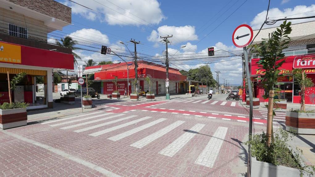 Estabelecimentos comerciais fechados em rua vazia com faixa de pedestres e semáforo fechado em Fortaleza