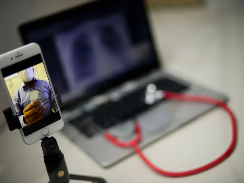 Consulta de telessaúde com médico utilizando notebook e estetoscópio